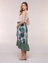 Vestido midi combinado de corte fluido. Presenta un torso ajustado acanalado sin mangas, con cuello redondo y sisas clásicas. Cuenta con cintura elastizada con lazo para anudar y falda evasé con estampado floral y geométrico, finalizando con un volante en el ruedo.