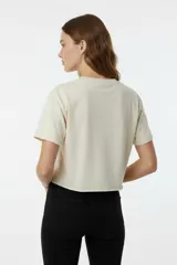 Remera de algodón color gris topo, con corte crop y ruedo sin costura. Presenta un estampado frontal de tres estrellas en tonos rojo, rosa y azul con efecto metalizado.