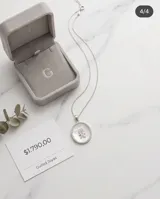 Dije circular de plata 925 con centro de nácar, borde engastado en circonias y figura central de niño con detalles en circonias.