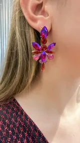 Caravanas colgantes de diseño floral compuestas por múltiples cristales facetados en tonos fucsia, violeta y rojo, engarzados en metal dorado.