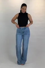 Pantalón jean de corte oxford y tiro medio, en tono azul intermedio. Cuenta con costuras verticales decorativas en el frente y bolsillos simulados con solapa a los costados de las caderas.