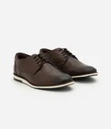 Zapato de vestir acordonado color marrón oscuro, de cuero, con suela blanca y detalles de costuras.