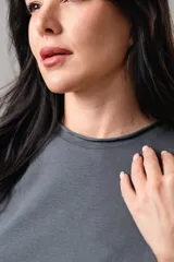Remera de algodón color gris oscuro, con cuello redondo y bordes con acabado desflecado en mangas y ruedo.