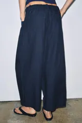 Pantalón de tiro medio confeccionado en mezcla de lyocell, con diseño de pierna ancha y tejido en espiga. Cuenta con cintura elástica ajustable con cordones y bolsillos laterales.