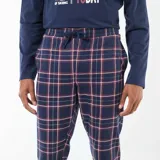Pijama de dos piezas compuesto por una remera de manga larga azul marino con estampado frontal de Mickey Mouse esquiando y un pantalón largo con diseño de cuadros en tonos azules, rojos y blancos, con puños elásticos en los tobillos.