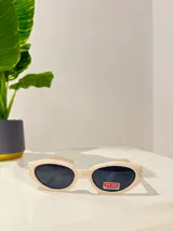 Lentes de sol color crema con forma ovalada y protección UV400.