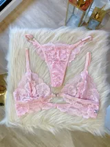 Conjunto de lencería compuesto por un bralette de encaje con cierre frontal y una tanga colaless a juego, ambos confeccionados en encaje suave y elastizado.