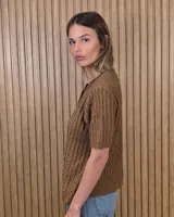 Cardigan calado de manga corta, tejido en punto con cierre frontal de botones y cuello redondo.
