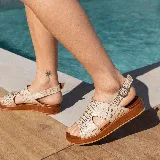 Sandalias de cuero color blanco con textura tipo reptil, plataforma marrón y hebilla metálica plateada.