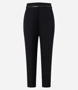 Pantalón de sastrería corte carrot, color beige, con cintura alta, pinzas frontales y cinturón fino incorporado con hebilla metálica.