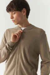 Campera tejida color beige con textura en el frontal, escote redondo y puños.