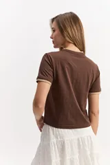 Remera de manga corta color gris melange, de calce regular y líneas simples, con detalles en contraste en el cuello y los puños.