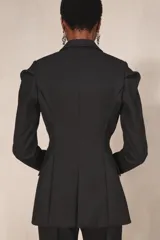 Blazer negro de corte recto de la colección Zara Studio, con solapas de muesca, cierre frontal de dos botones y bolsillos con solapa. Presenta mangas largas con pliegues estructurados en los hombros y forro interior a rayas a contraste.