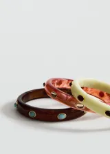 Set de tres pulseras rígidas de resina efecto carey en tonos verde claro, marrón oscuro y bordó, decoradas con apliques metálicos circulares con incrustaciones de piedras de colores.