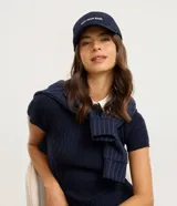 Gorra de sarga color negro con visera curva y bordado frontal en blanco con la frase "NOT YOUR BABE". Cuenta con regulador en la parte trasera.