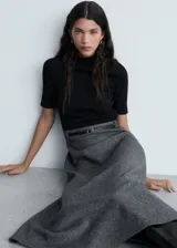 Vestido midi de diseño combinado con cuerpo de punto negro de cuello alto y manga corta, y falda evasé de tejido jaspeado en color gris. Incluye un cinturón fino negro con hebilla metálica.