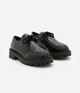 Zapato estilo desert shoe u oxford de Satinato, confeccionado en poliuretano (PU) negro con acabado texturizado. Presenta diseño de punta redonda, cordones al tono y suela gruesa tractorada de goma.