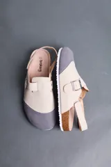 Sandalias Brokers Wear modelo Leblon White, de diseño bicolor en tonos beige y gris con puntera gris, tira ajustable con hebilla metálica y tira trasera.
