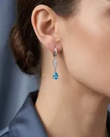 Caravanas colgantes de plata 925 con diseño de doble gota, una superior con pavé de circonias blancas y una inferior con una circonia central color celeste.