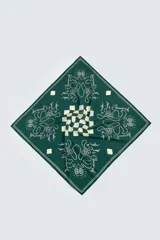 Bandana cuadrada de tela fluida color verde oscuro con estampado en blanco y beige. El diseño incluye un patrón de cuadros en el centro y motivos florales estilizados con texto manuscrito alrededor.