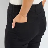 Pantalón de jeans negro de corte skinny, tiro alto y largo hasta el tobillo.