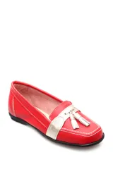 Mocasín de cuero negro con detalle de antifaz plateado y borlas.