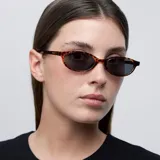 Gafas de sol con montura fina, estrecha y de forma ovalada con diseño carey. Lentes polarizadas color negro con protección UV400. Fabricadas con material Bio-based G850 y patillas de Propionato de Celulosa.