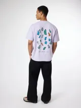 Camiseta lila de algodón orgánico, con corte oversize y estampado gráfico colorido en la espalda.