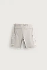 Bermuda cargo color negro de corte relaxed fit, confeccionada en tejido de algodón con elasticidad y efecto lavado. Cuenta con cintura elástica ajustable con cordón, bolsillos frontales y bolsillos laterales tipo cargo con solapa en las perneras.