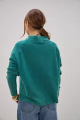 Sweater de punto color verde con cuello redondo y mangas largas.