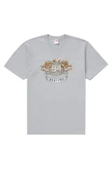 Remera de algodón gris con estampado frontal que presenta un escudo heráldico con leones dorados, una corona y el número 94 en efecto diamante, junto a una cinta con el logo de la marca.