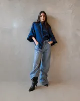 Jean de corte holgado y tiro medio, confeccionado en denim de lavado claro con aplicación de strass en toda la superficie. Presenta diseño de cinco bolsillos y cierre frontal con botón metálico.