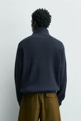 Sudadera de corte relajado confeccionada en tejido de algodón con textura waffle. Presenta cuello subido con cierre frontal de cuatro botones y mangas largas con puños y ruedo en rib.