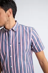 Camisa de corte slim fit con estampado de cuadros en tonos rojos, azules, blancos y negros. Presenta cuello clásico, cierre frontal abotonado y logo bordado en el pecho.