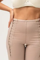 Calza capri color piel, de tela de faja de alta contención, con broches laterales reforzados con dos medidas y orificio sanitario en la entrepierna.