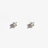 Par de aros tipo stud dorados, con engaste de cuatro puntas, cada uno con una piedra de cristal transparente redonda.