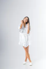 Bata corta color blanco de satén elastizado, con mangas tres cuartos con volados y lazo para atar en la cintura.