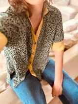 Camisa de manga corta con estampado animal print en tonos grises y amarillos.