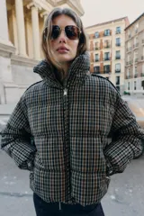 Anorak acolchado de cuello subido y manga larga con puños elásticos ajustables. Presenta un diseño de cuadros, cierre frontal con cremallera, bolsillos laterales con cierre y bajo ajustable con cordones elásticos.