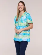 Blusa de rayón en tonos turquesa y verde, con cuello en V con detalles bordados, mangas cortas amplias y diseño estampado con motivos florales y geométricos.