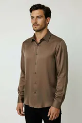 Camisa de poliéster color marrón, de corte holgado, con mangas largas, cuello camisero clásico y cierre frontal de botones.