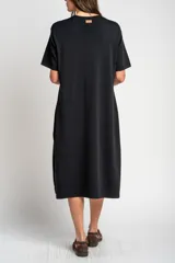 Vestido midi de punto negro con pequeño bordado de un velero en el pecho, mangas cortas y tajo lateral en el dobladillo.