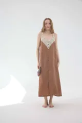 Vestido midi lencero marrón de lino, con escote en V pronunciado con aplique de encaje en contraste, breteles regulables y botonadura frontal decorativa.