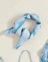 Conjunto de bikini celeste y blanco con estampado de mariposas y pañuelo a juego.