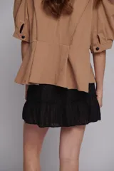 Chaqueta o blusa de tejido natural color verde menta, con mangas balloon y un botón decorativo en forma de estrella de mar. El cuerpo tiene un ruedo evasé.