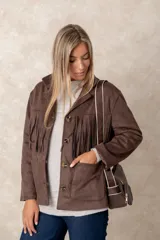 Cartera bandolera color chocolate con textura granulada, que incluye un monedero circular desmontable sujeto a la correa. Posee cierre superior y correa ajustable con detalles en color crema.