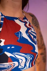 Top deportivo con estampado abstracto en tonos rojo, azul y blanco.