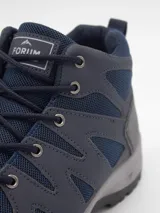 Bota de trekking Forum color azul marino, con paneles de malla transpirable, refuerzos sintéticos en puntera y laterales, y suela de goma gris con relieve antideslizante.