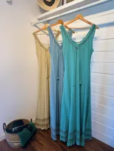 Vestido largo de algodón color celeste, con breteles finos y escote en V. Presenta un estampado geométrico en el ruedo.