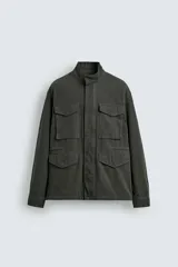 Cazadora regular fit de algodón color gris oscuro con efecto lavado, cuello subido, manga larga y cierre frontal con cremallera oculta por solapa con botones a presión. Cuenta con cuatro bolsillos frontales de plastrón con solapa y cintura ajustable con cordón interior.